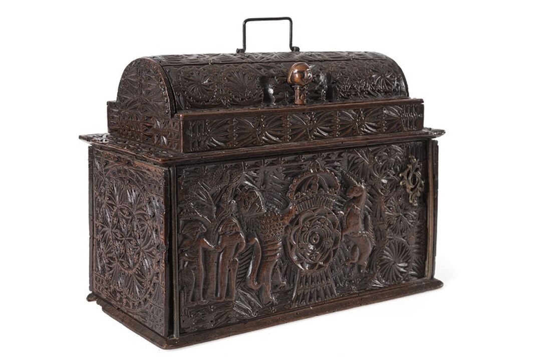 A wooden box that resembles a treasure chest with lots of detailed carvings.