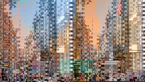 Bustling Buchanan Street in Glasgow with shops and pedestrians under a sunny sky.